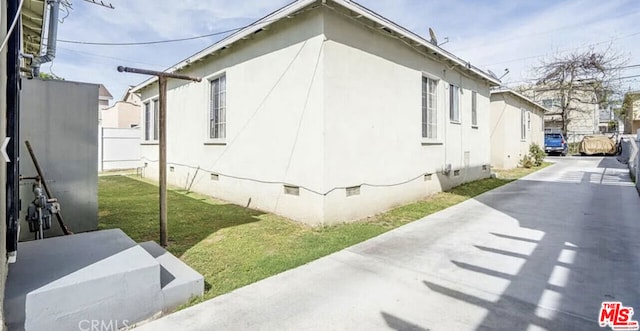 view of side of property with a lawn and a patio