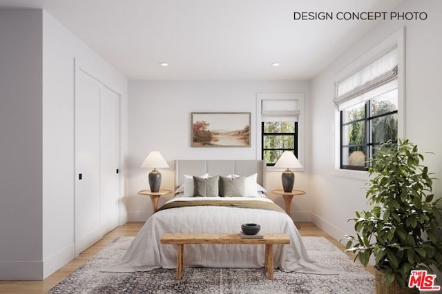 bedroom with light hardwood / wood-style floors and a closet