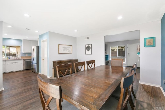 dining room with sink and dark hardwood / wood-style flooring