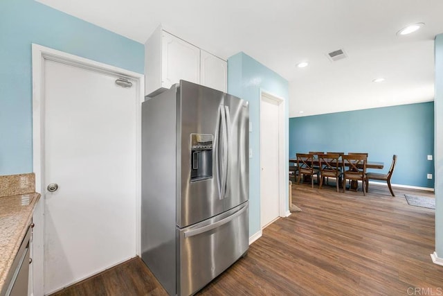 kitchen featuring stainless steel fridge, white cabinetry, and dark hardwood / wood-style floors