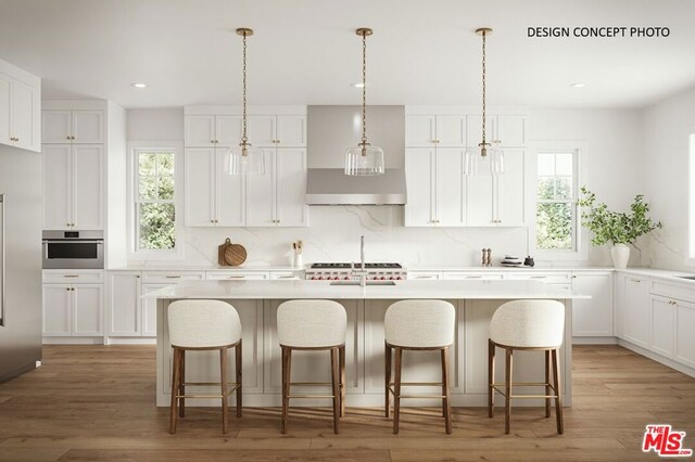 kitchen featuring a center island with sink, stainless steel oven, decorative backsplash, white cabinetry, and decorative light fixtures