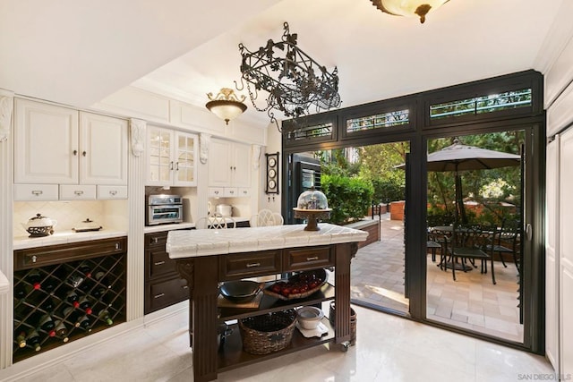 interior space featuring white cabinets, dark brown cabinetry, tasteful backsplash, and tile counters