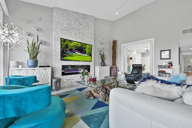 living room featuring ceiling fan and a fireplace