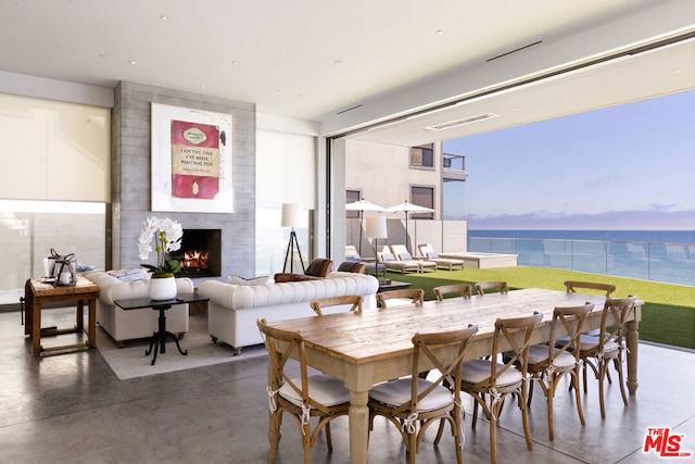 dining area with a fireplace and a water view