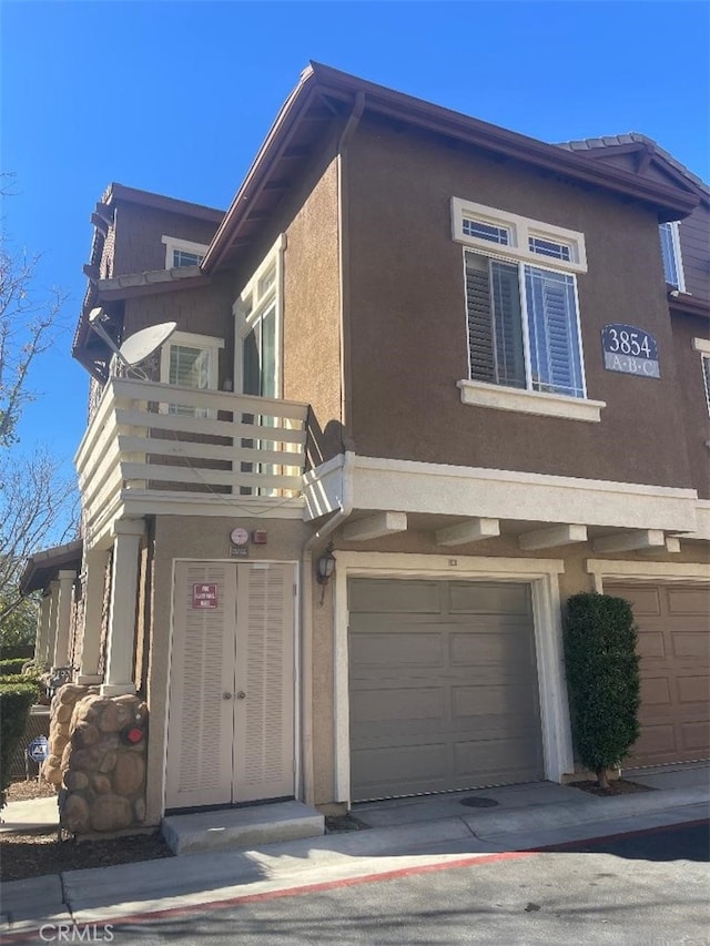 view of home's exterior featuring a balcony and a garage