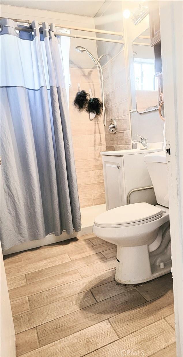 bathroom featuring a shower with curtain, toilet, and vanity