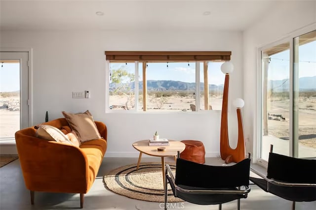 sitting room featuring concrete flooring and a mountain view