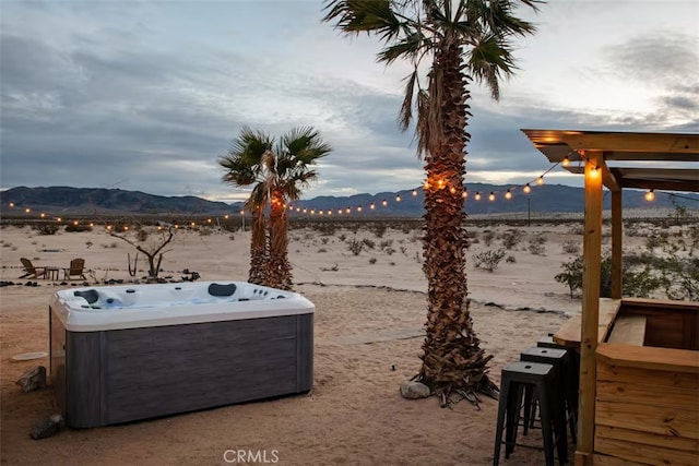 view of yard with a water and mountain view, a patio area, and a hot tub