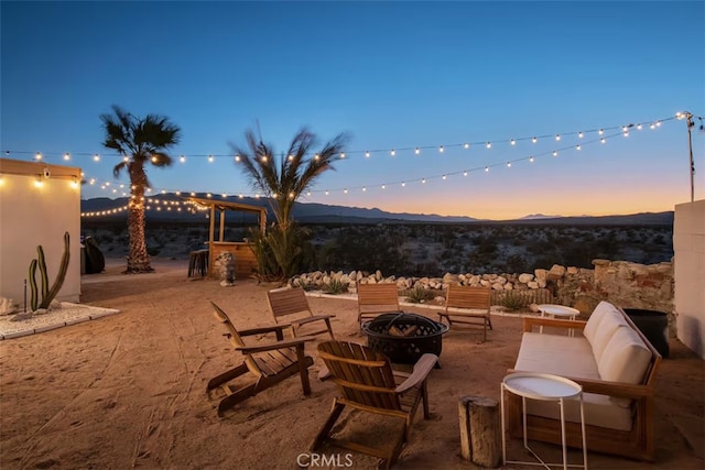 patio terrace at dusk with a mountain view and a fire pit