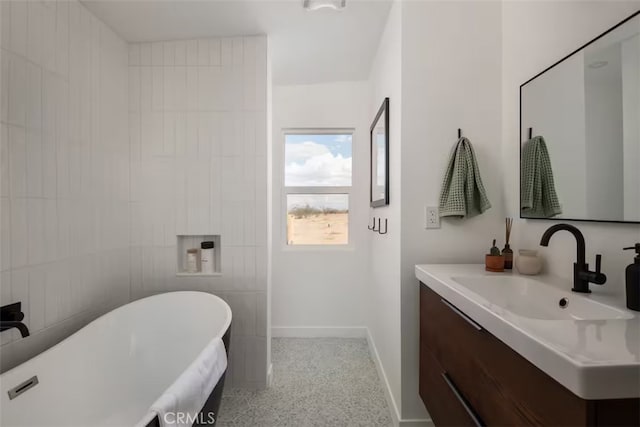 bathroom with a washtub and vanity