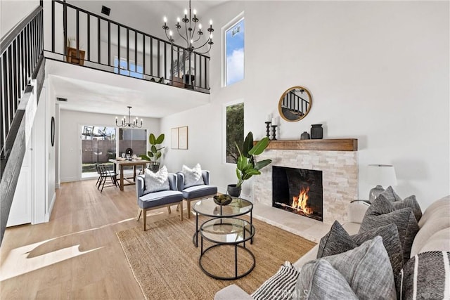 living room featuring a notable chandelier, light wood-type flooring, and a fireplace