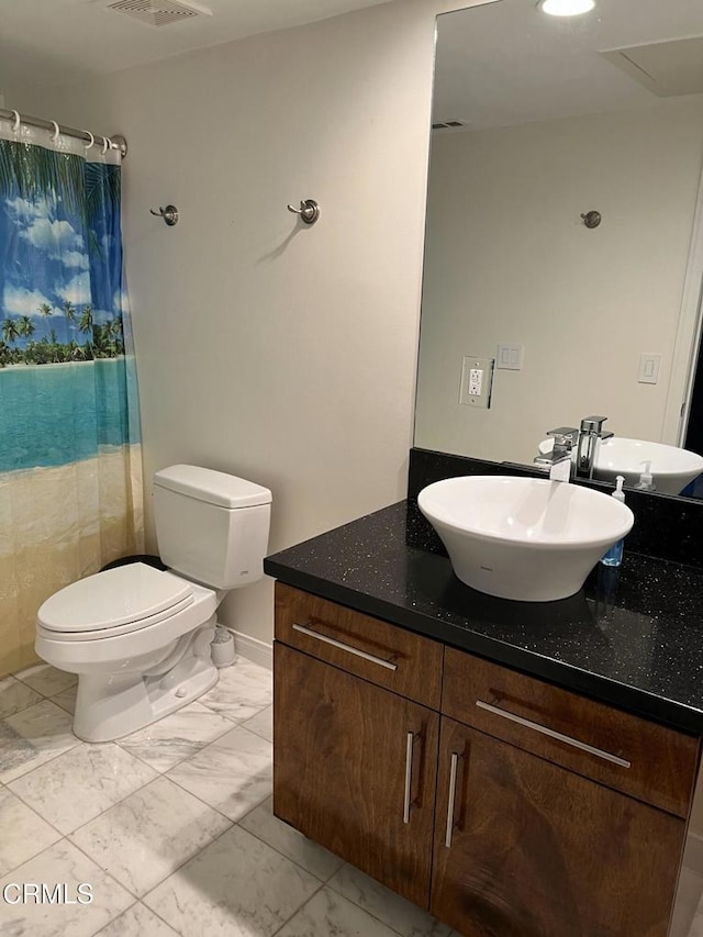 bathroom with curtained shower, vanity, and toilet