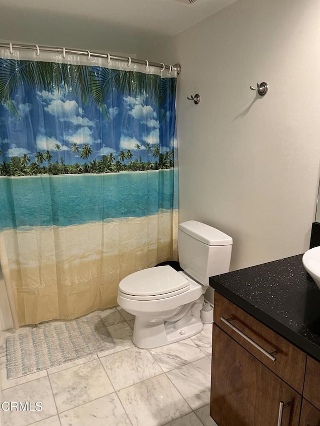 bathroom featuring toilet, walk in shower, and vanity