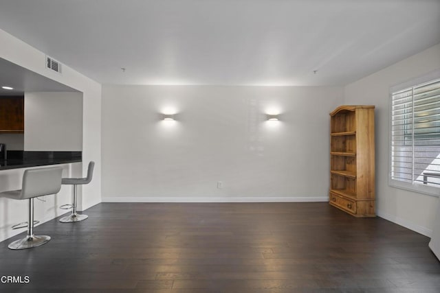 living room featuring baseboards, visible vents, and dark wood finished floors