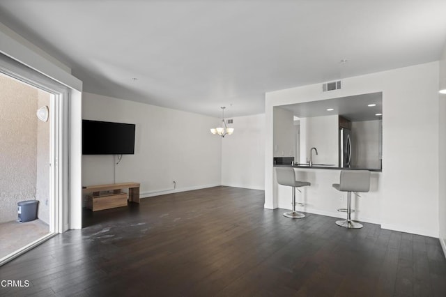 unfurnished living room featuring dark wood finished floors, recessed lighting, visible vents, a chandelier, and baseboards