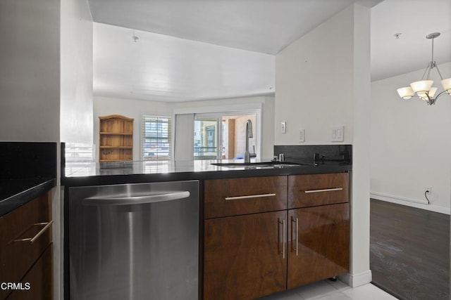 kitchen featuring dark countertops, a sink, stainless steel dishwasher, and modern cabinets