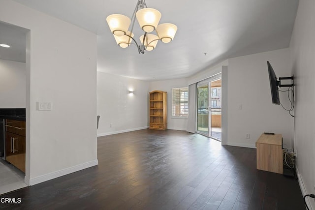 1200 Pacific Coast Hwy Unit 108, Huntington Beach, CA 92648 - unfurnished living room featuring dark wood-style floors, a notable chandelier, and baseboards