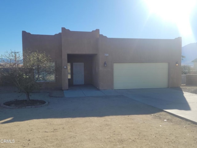 pueblo-style home with a garage