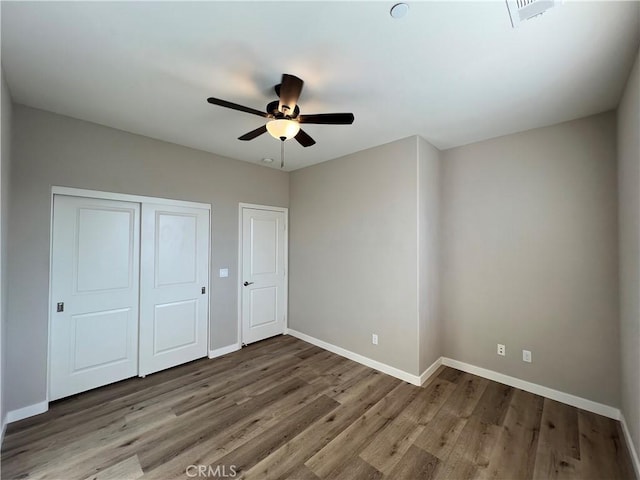 unfurnished bedroom with ceiling fan and hardwood / wood-style flooring