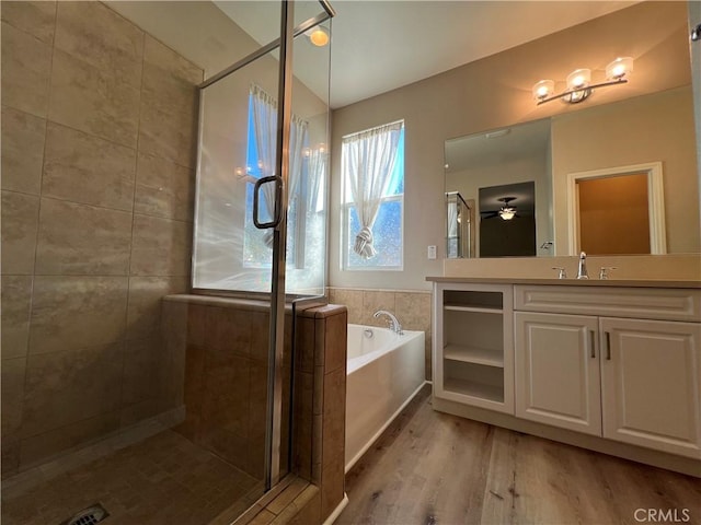 bathroom featuring ceiling fan, vanity, independent shower and bath, and hardwood / wood-style floors