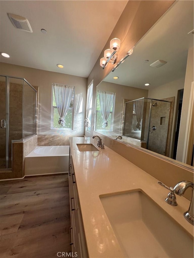 bathroom with vanity, independent shower and bath, and hardwood / wood-style flooring