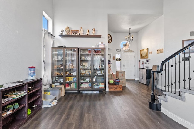 entrance foyer featuring dark wood-type flooring, a high ceiling, and a notable chandelier