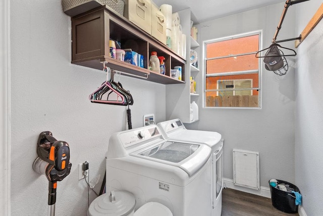 washroom with dark wood-type flooring and washer and clothes dryer