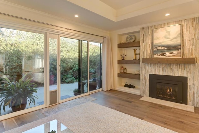 doorway with hardwood / wood-style flooring, crown molding, and built in features