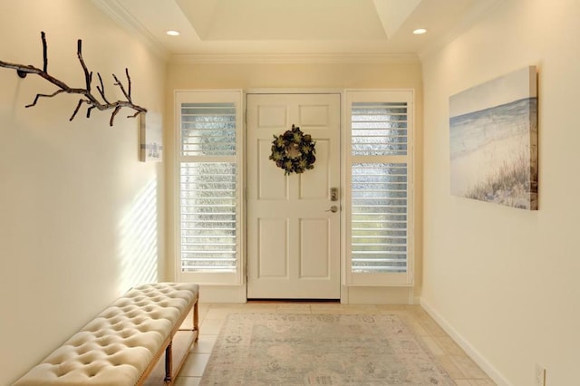 entrance foyer with light tile patterned flooring, crown molding, and a tray ceiling