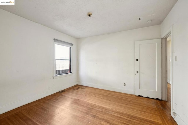 spare room with hardwood / wood-style floors