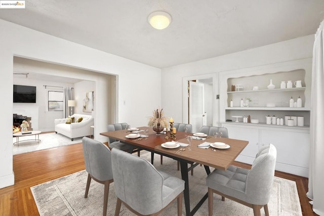 dining area featuring wood-type flooring and built in features