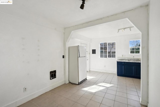 interior space with sink, light tile patterned flooring, and track lighting