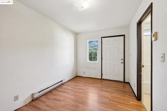 unfurnished bedroom with baseboard heating and light wood-type flooring