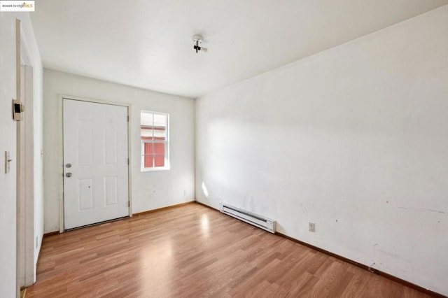 foyer entrance featuring a baseboard radiator and light wood-type flooring