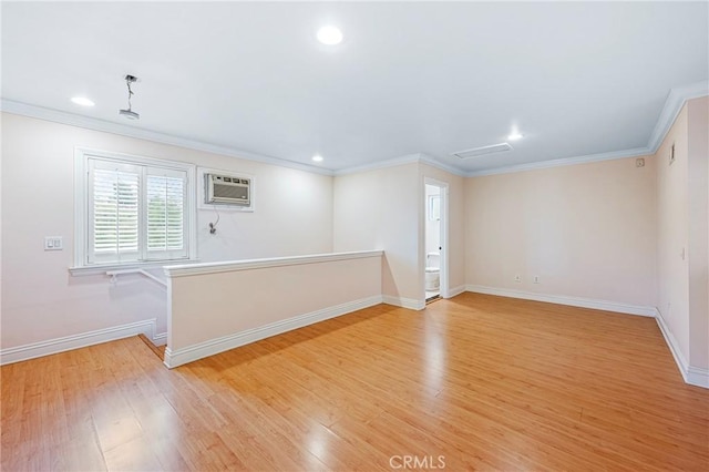 empty room with ornamental molding, light hardwood / wood-style floors, and an AC wall unit