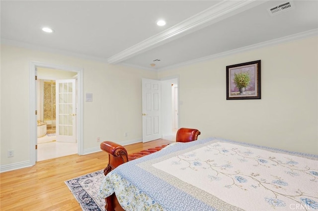 bedroom with wood-type flooring, connected bathroom, and crown molding