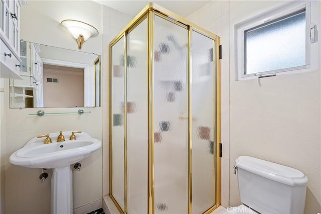 bathroom with toilet and a shower with door