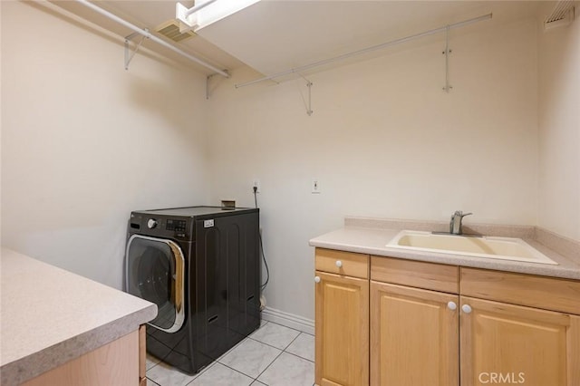 clothes washing area featuring washer / dryer, cabinets, light tile patterned floors, and sink