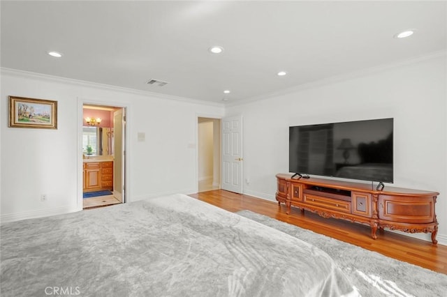 bedroom with ensuite bathroom, crown molding, and wood-type flooring