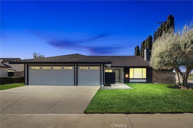 view of front of house featuring a garage and a lawn