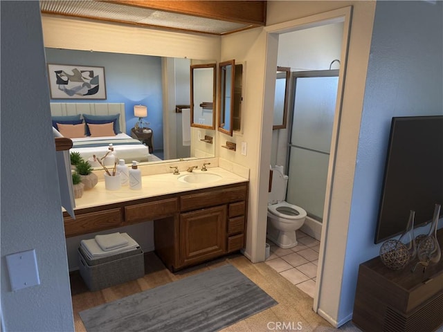 bathroom featuring toilet, an enclosed shower, vanity, and tile patterned floors