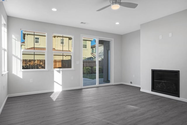 unfurnished living room with ceiling fan and dark hardwood / wood-style floors