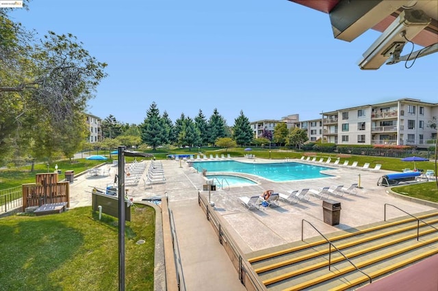 view of swimming pool featuring a lawn