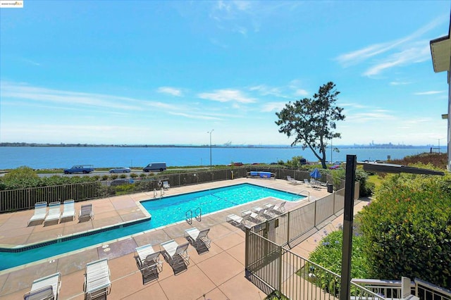 view of pool featuring a patio and a water view