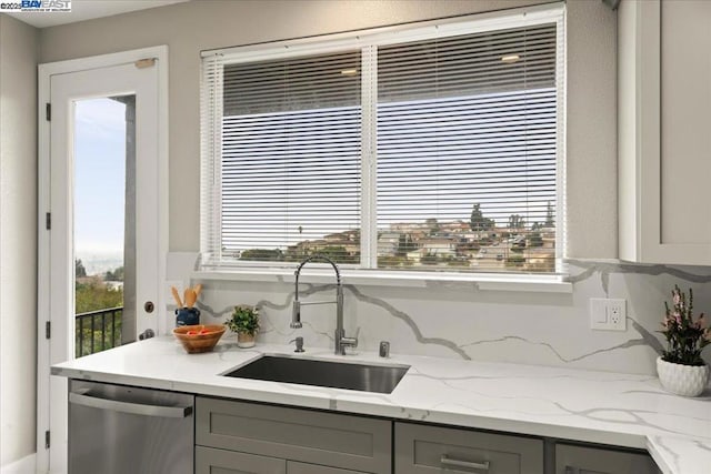 kitchen with sink, dishwasher, gray cabinets, and light stone countertops