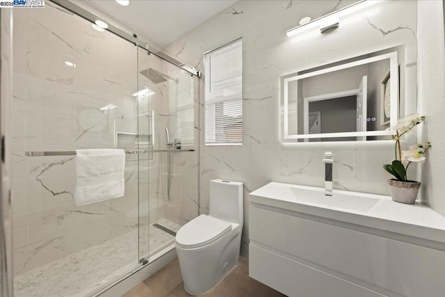 bathroom with a shower with door, vanity, and toilet