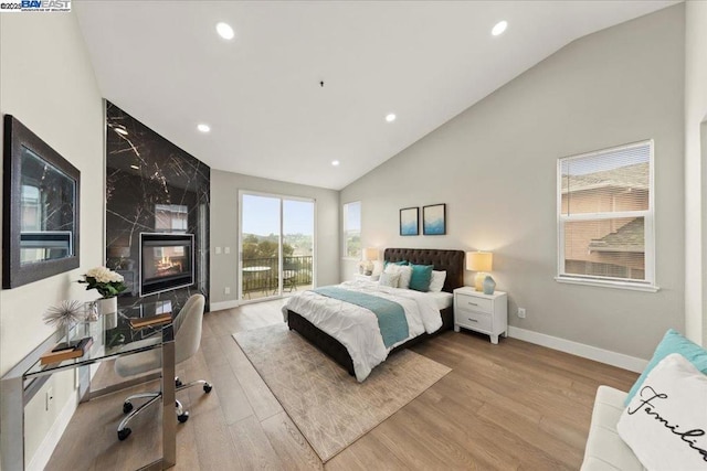 bedroom with light hardwood / wood-style flooring, vaulted ceiling, and access to exterior