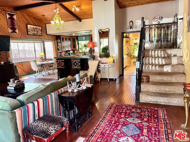 living room featuring dark hardwood / wood-style flooring, an inviting chandelier, wooden ceiling, and vaulted ceiling with beams