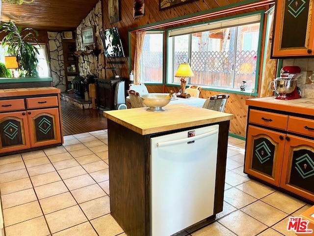 kitchen with light tile patterned floors, dishwasher, wood ceiling, and wood counters