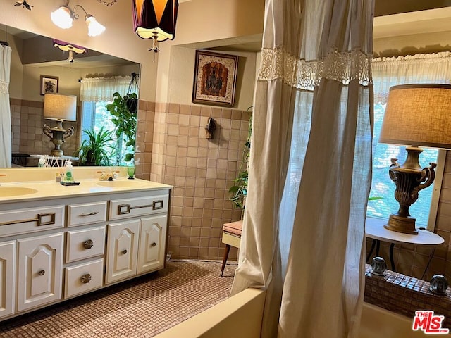 bathroom with tile walls, tile patterned flooring, and vanity